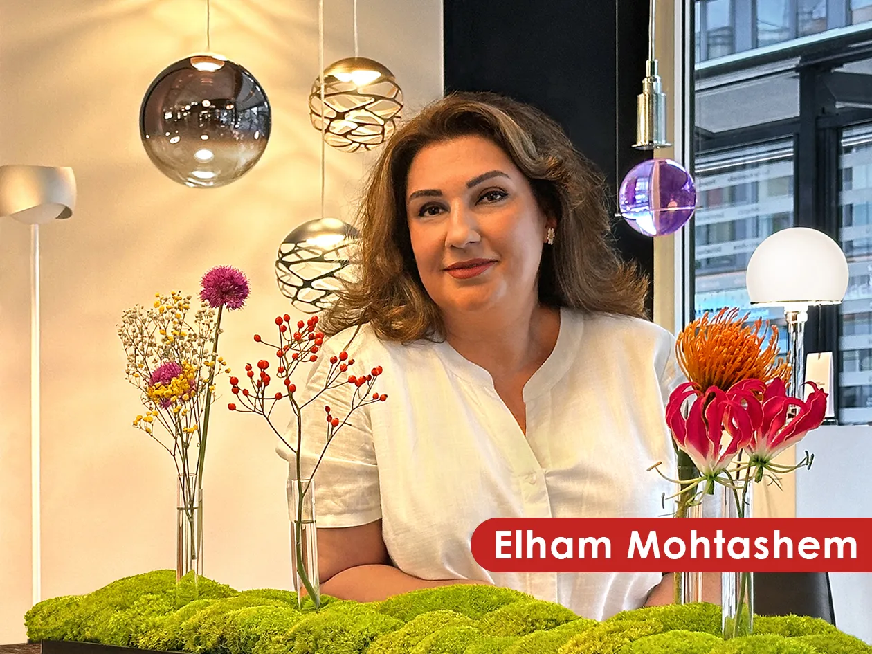 Elham Mohtashem im Showroom von ars vivendi zwischen Pendelleuchten und Blumen