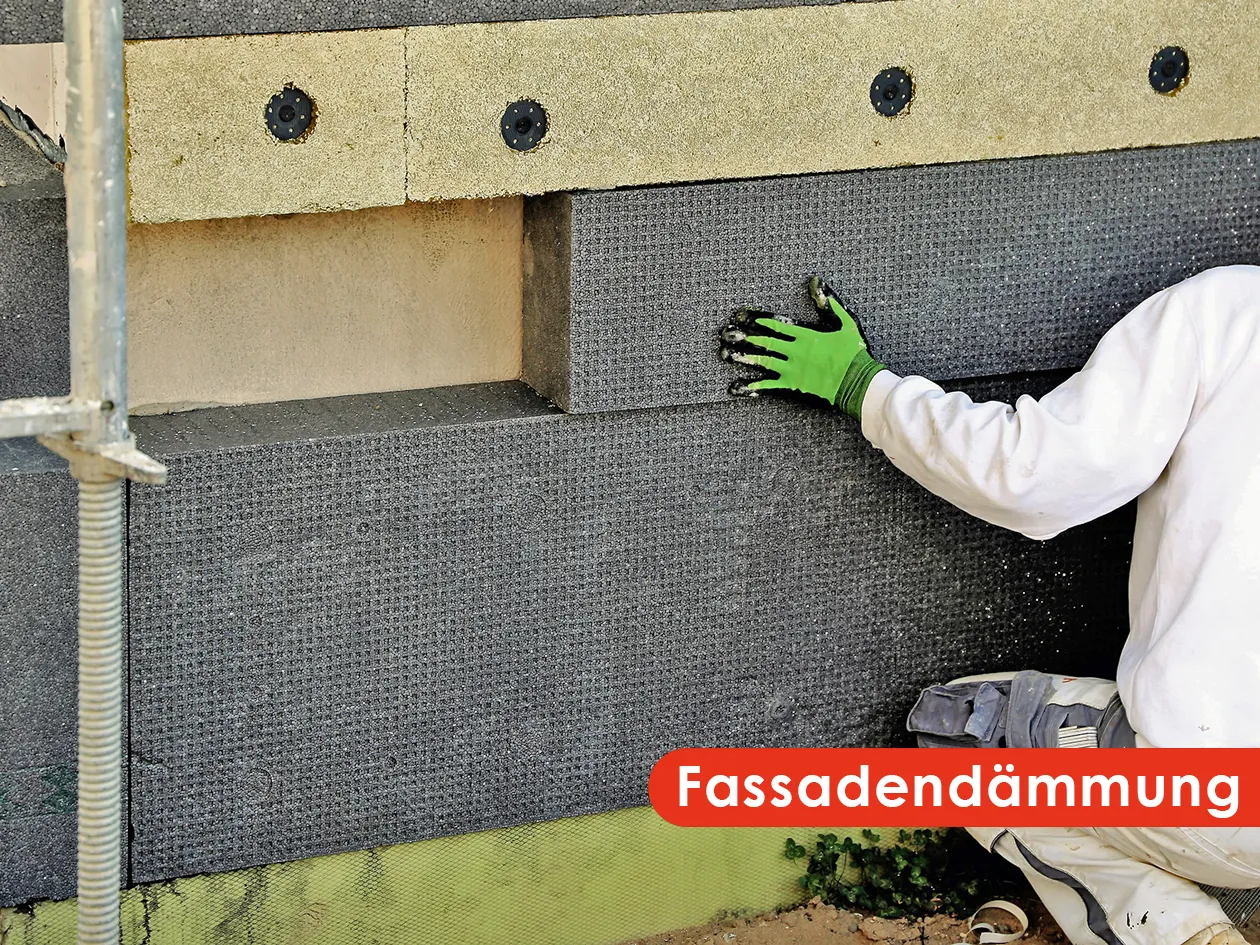 Maler bringt Dämmplatten für eine Fassadendämmung an