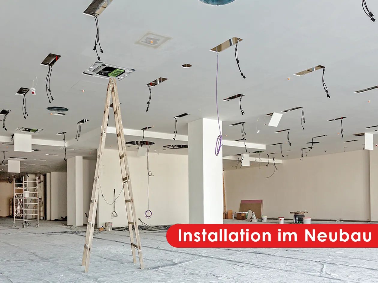 Installation im Neubau: offene Decke mit herabhängenden Leitungen